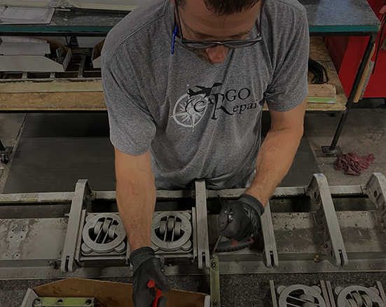 Cargo Repair mechanic working on cargo rollers
